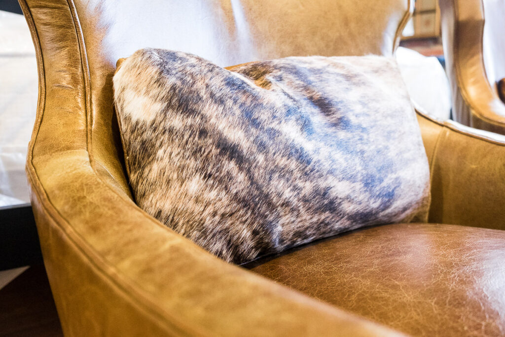 animal print patterned pillow on a light brown leather couch